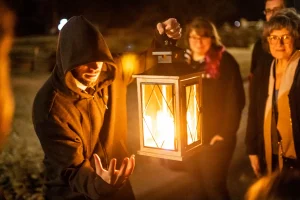 A guide holding a lantern striking a pose